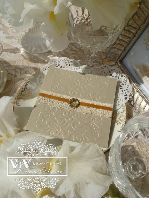 Esküvői meghívó csipkével díszítve óarany színben brossal